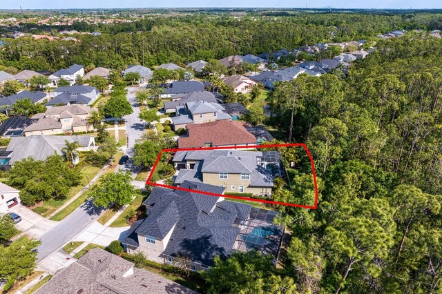 aerial perspective of suburban area featuring property boundaries highlighted and a heavily wooded area