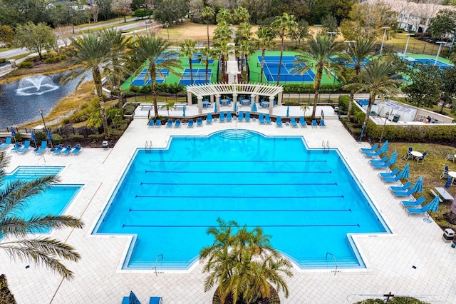 community pool with a patio area and fence