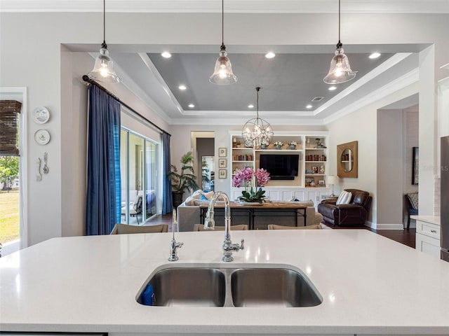1104 Isobel Reserve Ln, Tampa, FL 33613 - kitchen featuring a sink, open floor plan, light countertops, a raised ceiling, and crown molding