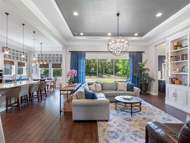 1104 Isobel Reserve Ln, Tampa, FL 33613 - living area with plenty of natural light, dark wood-type flooring, a chandelier, a tray ceiling, and a textured ceiling