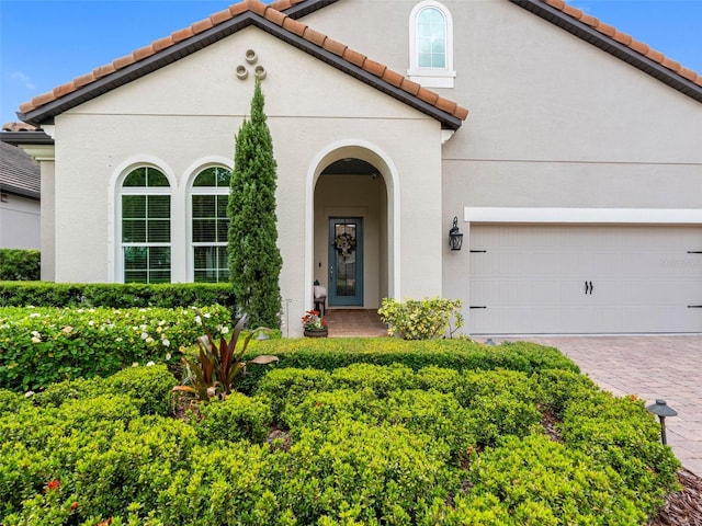 1104 Isobel Reserve Ln, Tampa, FL 33613 - mediterranean / spanish home featuring a tile roof, stucco siding, driveway, and an attached garage