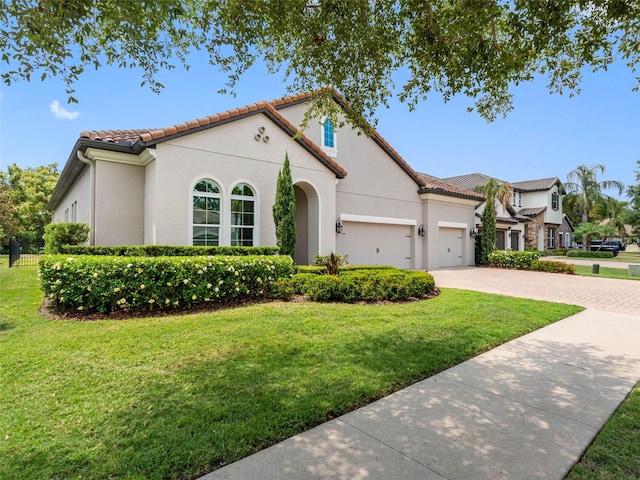 1104 Isobel Reserve Ln, Tampa, FL 33613 - mediterranean / spanish house with stucco siding, driveway, a garage, and a front yard