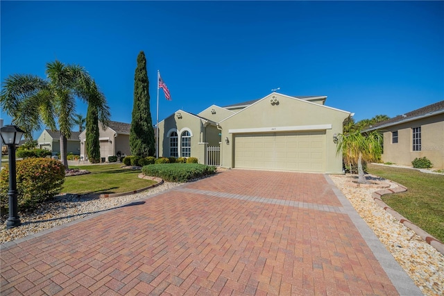 445 Noble Faire Dr, Sun City Center, FL 33573 - view of front of house with a garage, decorative driveway, stucco siding, and a front yard