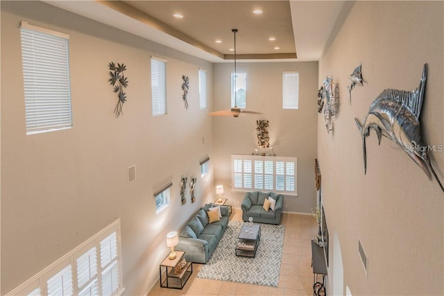 445 Noble Faire Dr, Sun City Center, FL 33573 - living room featuring light tile patterned floors, recessed lighting, a tray ceiling, baseboards, and a towering ceiling
