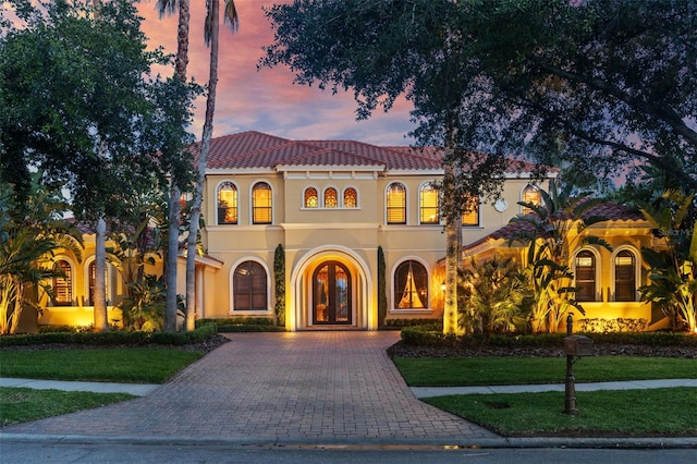 11817 Glen Wessex Ct, Tampa, FL 33626 - mediterranean / spanish-style house with driveway, a front lawn, a tile roof, and stucco siding