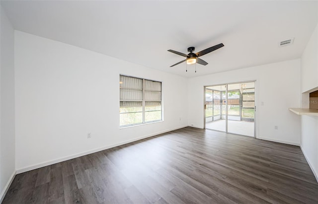 7763 Jenner Ave, New Port Richey, FL 34655 - unfurnished living room featuring dark wood-type flooring, a ceiling fan, and baseboards