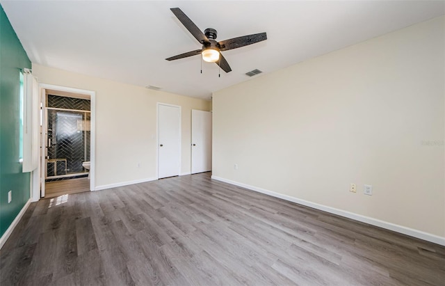7763 Jenner Ave, New Port Richey, FL 34655 - unfurnished bedroom with wood finished floors, baseboards, ensuite bath, and a ceiling fan