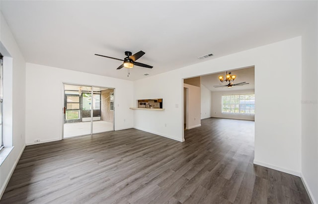 7763 Jenner Ave, New Port Richey, FL 34655 - unfurnished living room featuring a chandelier, wood finished floors, a ceiling fan, and baseboards