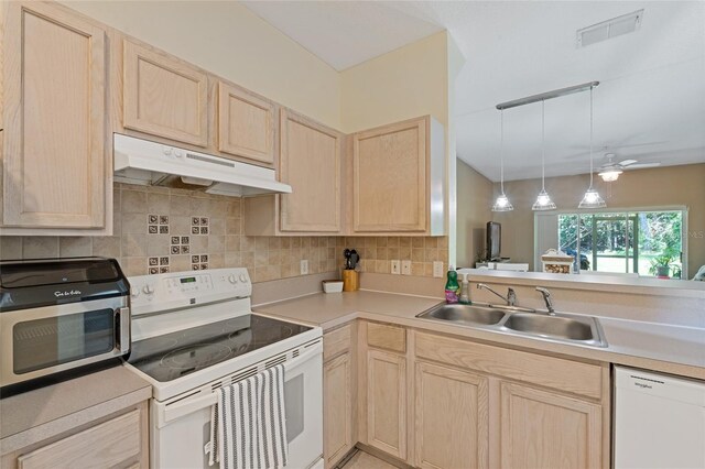 11162 Kapok Grand Cir, Madeira Beach, FL 33708 - kitchen featuring white appliances, under cabinet range hood, light brown cabinets, and light countertops