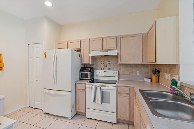 11162 Kapok Grand Cir, Madeira Beach, FL 33708 - kitchen featuring white appliances, under cabinet range hood, light brown cabinets, light tile patterned floors, and backsplash