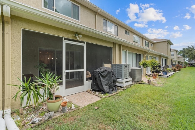 11162 Kapok Grand Cir, Madeira Beach, FL 33708 - back of house with a yard, stucco siding, and a sunroom