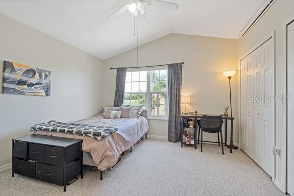11162 Kapok Grand Cir, Madeira Beach, FL 33708 - carpeted bedroom featuring lofted ceiling and ceiling fan