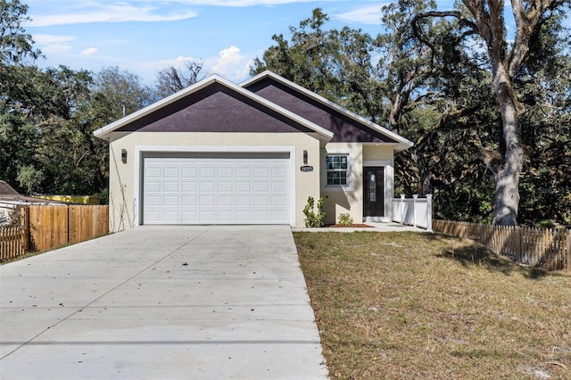 single story home with concrete driveway, a garage, fence, and a front yard