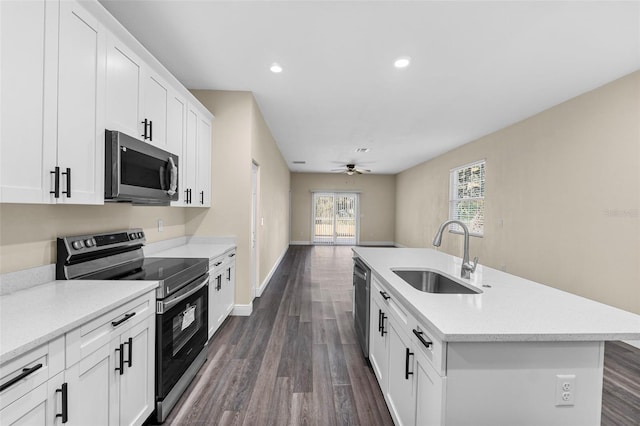 kitchen featuring a sink, dark wood-style flooring, stainless steel appliances, and an island with sink