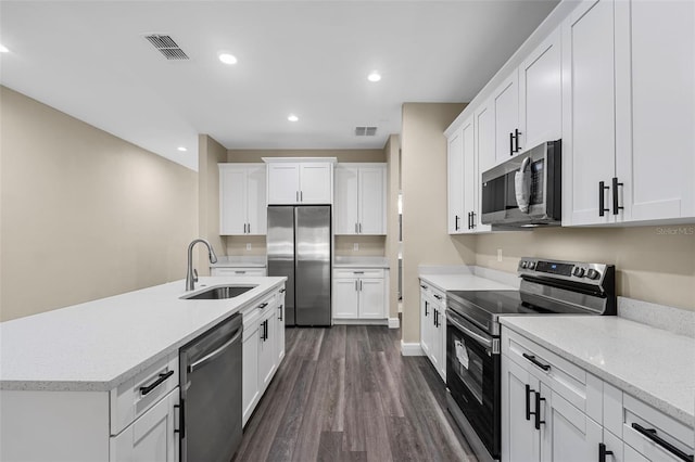 kitchen with a sink, stainless steel appliances, dark wood-type flooring, and white cabinets