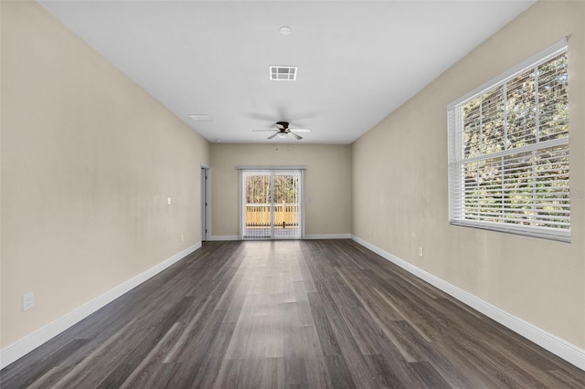 unfurnished room featuring baseboards, ceiling fan, visible vents, and dark wood-style floors