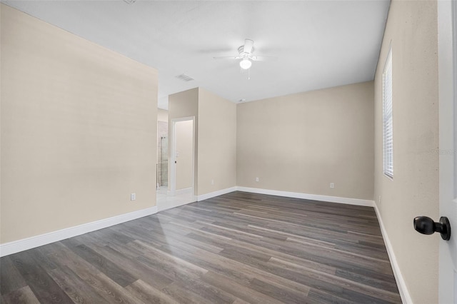 empty room featuring visible vents, baseboards, a ceiling fan, and dark wood-type flooring