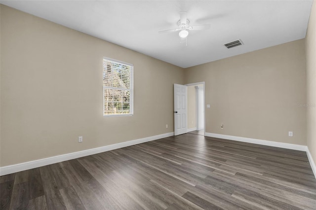 empty room featuring dark wood finished floors, visible vents, baseboards, and ceiling fan
