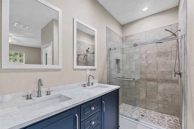 full bath featuring double vanity, visible vents, a shower stall, and a sink