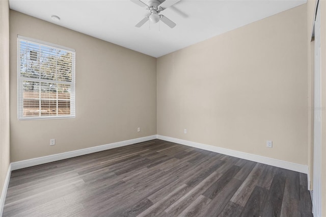 empty room with dark wood-type flooring, baseboards, and a ceiling fan