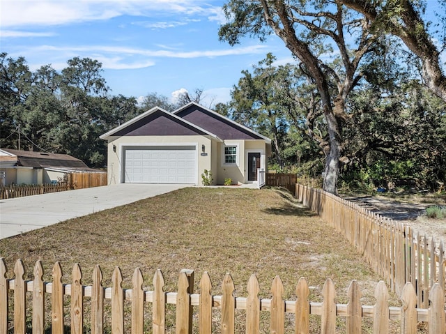 single story home featuring driveway, an attached garage, stucco siding, fence private yard, and a front yard