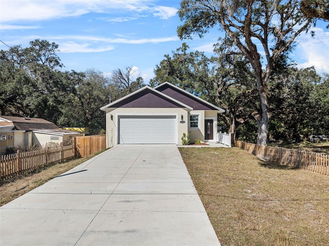 ranch-style house featuring fence, driveway, a garage, stucco siding, and a front yard
