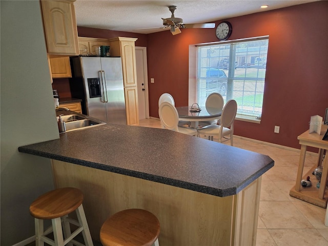 827 Creekside Ln, Palm Harbor, FL 34684 - kitchen with stainless steel refrigerator with ice dispenser, a peninsula, dark countertops, light brown cabinets, and a ceiling fan