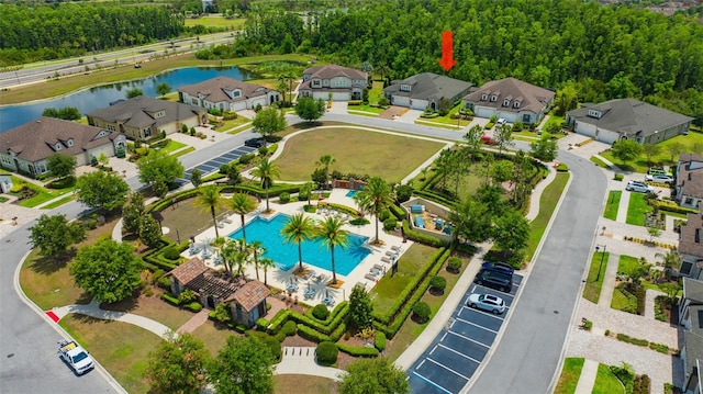 aerial view of residential area with a nearby body of water and a pool area