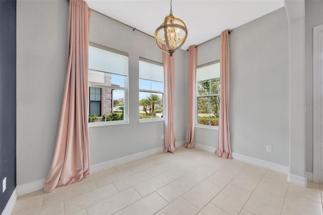 unfurnished room with a chandelier, light tile patterned floors, and baseboards