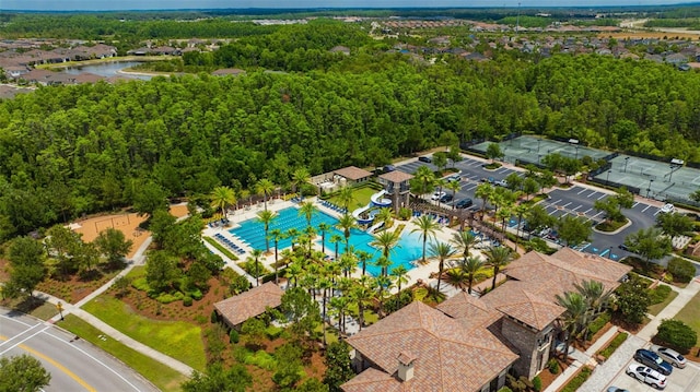 aerial view of a pool area and a nearby body of water