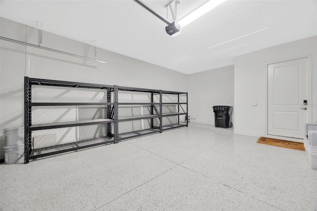 garage featuring a garage door opener and baseboards
