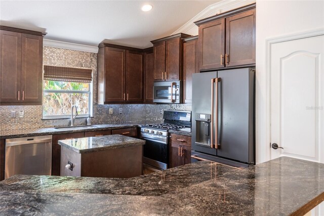 2008 Berry Lake Dr, Brandon, FL 33510 - kitchen featuring dark stone countertops, a sink, stainless steel appliances, crown molding, and a kitchen island