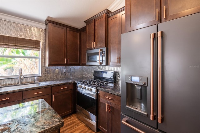 2008 Berry Lake Dr, Brandon, FL 33510 - kitchen with wood finished floors, dark stone countertops, a sink, backsplash, and appliances with stainless steel finishes