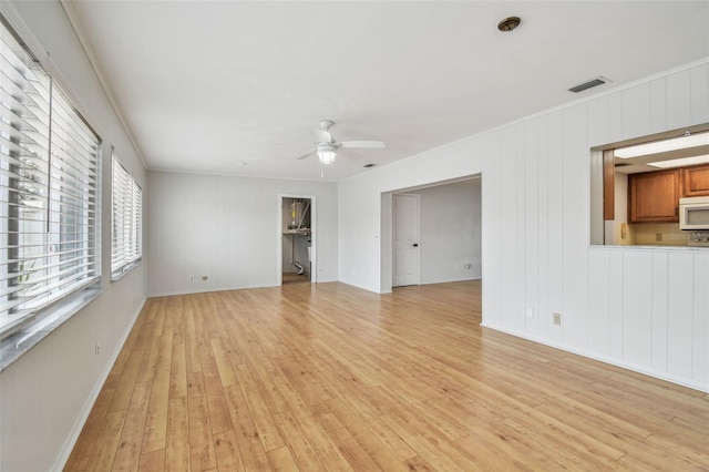 11762 82nd Ter, Seminole, FL 33772 - unfurnished living room with ceiling fan, light wood-style flooring, and baseboards