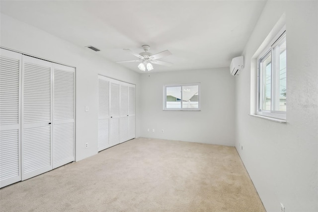11762 82nd Ter, Seminole, FL 33772 - unfurnished bedroom with a wall mounted air conditioner, multiple closets, multiple windows, and carpet