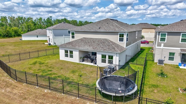 12710 Hysmith Loop, Parrish, FL 34219 - back of house featuring a trampoline, roof with shingles, cooling unit, stucco siding, and a patio area