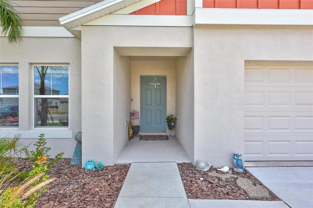 12710 Hysmith Loop, Parrish, FL 34219 - view of exterior entry with a garage and stucco siding