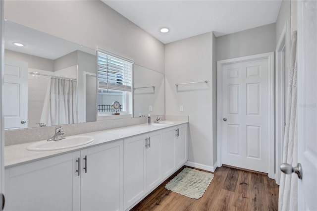 12710 Hysmith Loop, Parrish, FL 34219 - bathroom featuring wood finished floors, double vanity, baseboards, and a shower with curtain