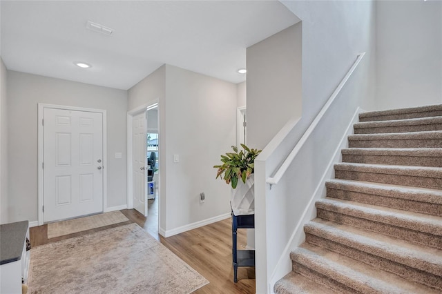 12710 Hysmith Loop, Parrish, FL 34219 - foyer entrance with stairway, light wood-style flooring, baseboards, and recessed lighting