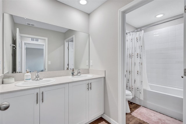 12710 Hysmith Loop, Parrish, FL 34219 - bathroom with wood finished floors, toilet, double vanity, and shower / bath combo