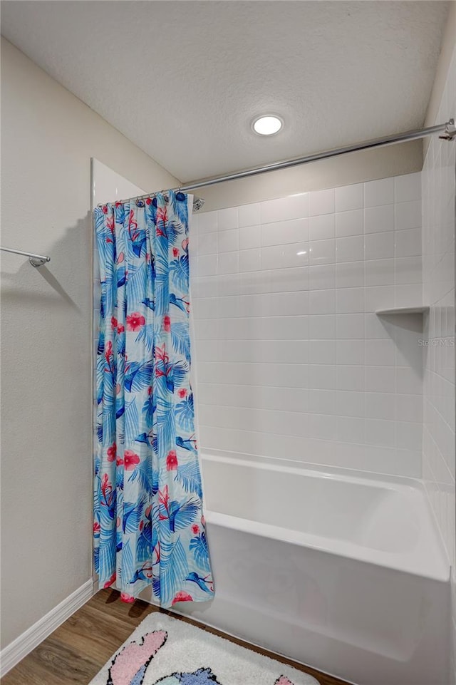 12710 Hysmith Loop, Parrish, FL 34219 - full bath with baseboards, wood finished floors, shower / bath combo, recessed lighting, and a textured ceiling