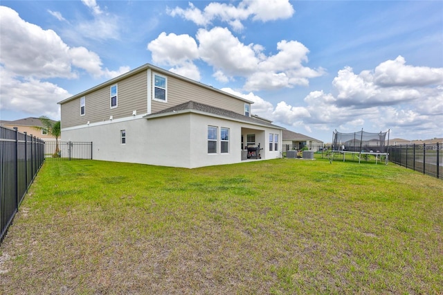12710 Hysmith Loop, Parrish, FL 34219 - back of house with a trampoline and stucco siding