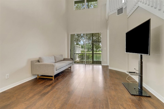 1330 Mariposa Cir Unit 104, Naples, FL 34105 - living area featuring a towering ceiling, healthy amount of natural light, and wood finished floors
