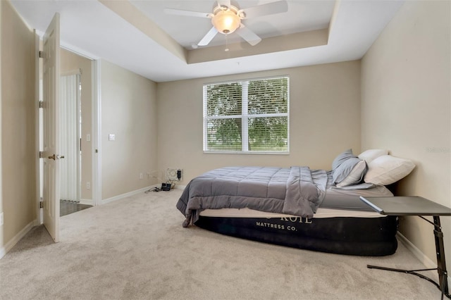 1330 Mariposa Cir Unit 104, Naples, FL 34105 - bedroom featuring carpet floors, a tray ceiling, and ceiling fan