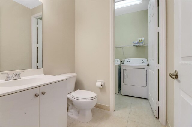 1330 Mariposa Cir Unit 104, Naples, FL 34105 - half bathroom featuring washer and clothes dryer, vanity, and tile patterned flooring