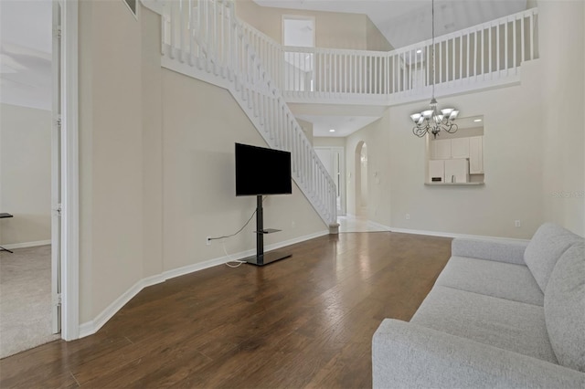 1330 Mariposa Cir Unit 104, Naples, FL 34105 - living area featuring stairs, wood finished floors, a chandelier, arched walkways, and a towering ceiling