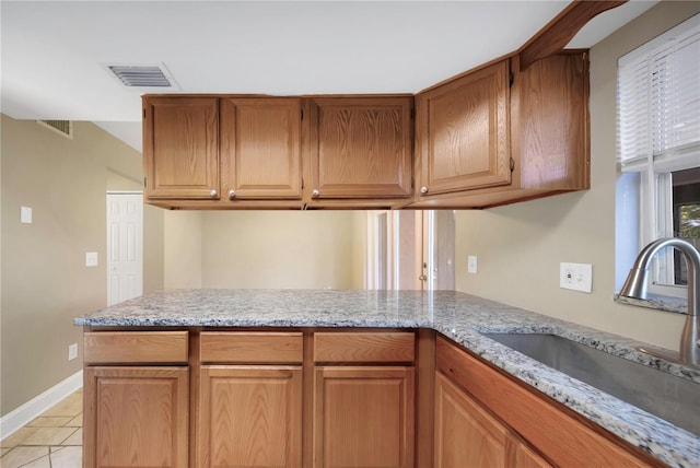 2048 Los Lomas Dr, Clearwater, FL 33763 - kitchen featuring a sink, light stone counters, light tile patterned floors, and a peninsula