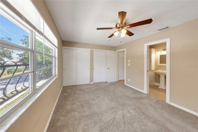 2048 Los Lomas Dr, Clearwater, FL 33763 - unfurnished bedroom with multiple closets, carpet floors, baseboards, ensuite bathroom, and a sink