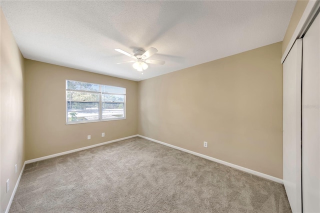 2048 Los Lomas Dr, Clearwater, FL 33763 - unfurnished bedroom featuring carpet, a closet, baseboards, a textured ceiling, and ceiling fan