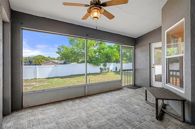 unfurnished sunroom with ceiling fan
